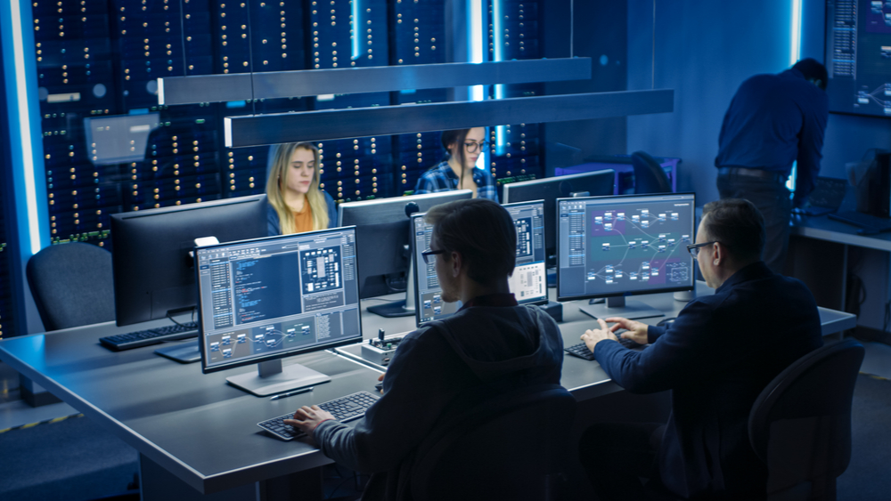 A team of security analysts working together inside of a server room. 