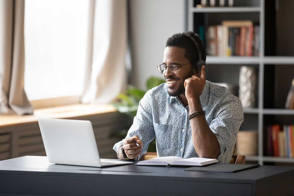 Employee looking at their laptop smiling. 