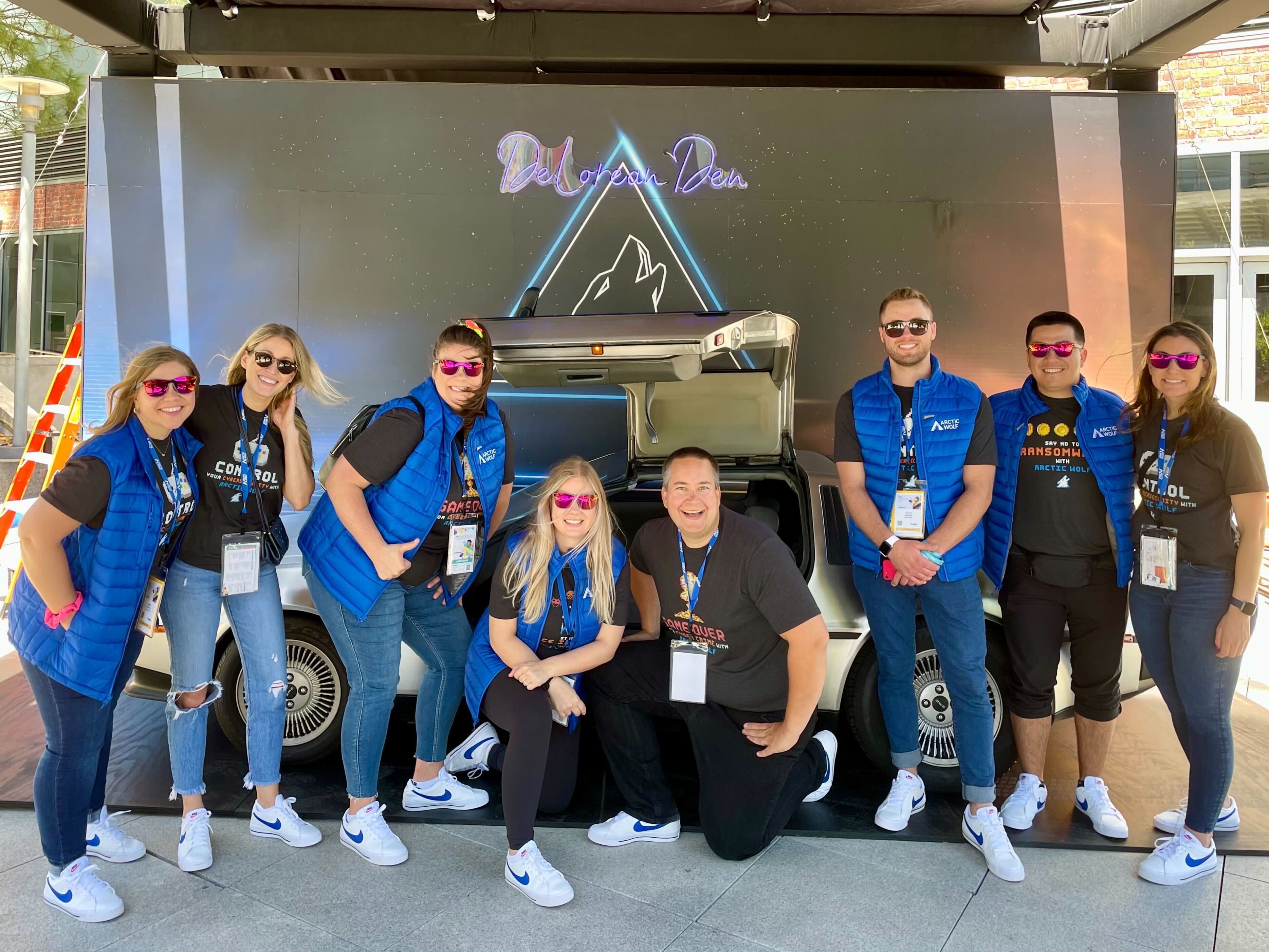 The Arctic Wolf team in front of a DeLorean. 