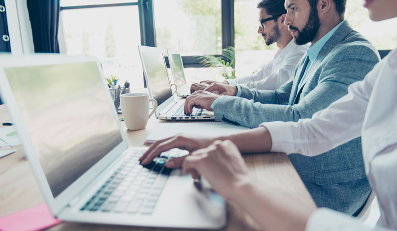 Three office employees at their computers. 