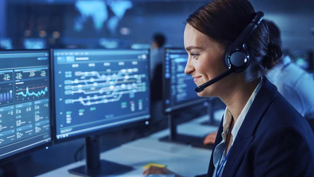 A security operations employee looking at a group of monitors. 