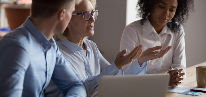 Three employees in a meeting in a discussion. 