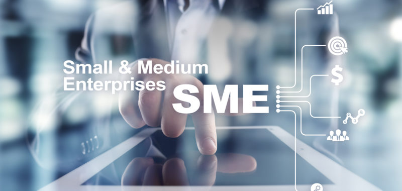 A screen being touched with "small and medium Enterprises" written in the foreground 