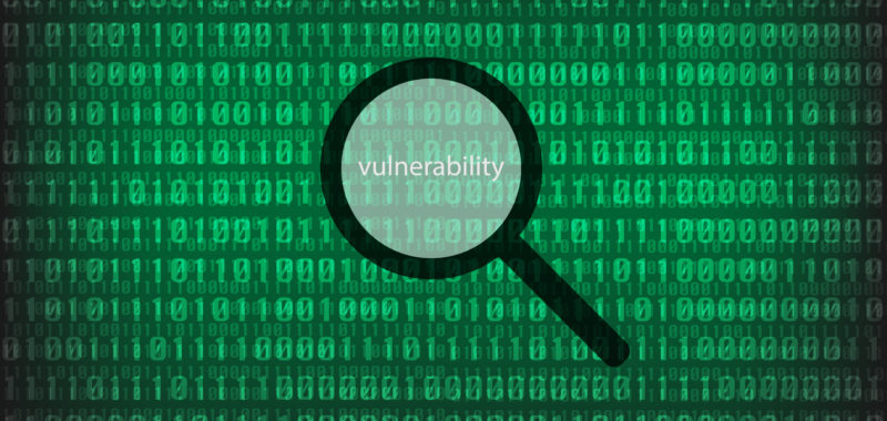 A binary code background with a magnifying glass above the word "vulnerability" 