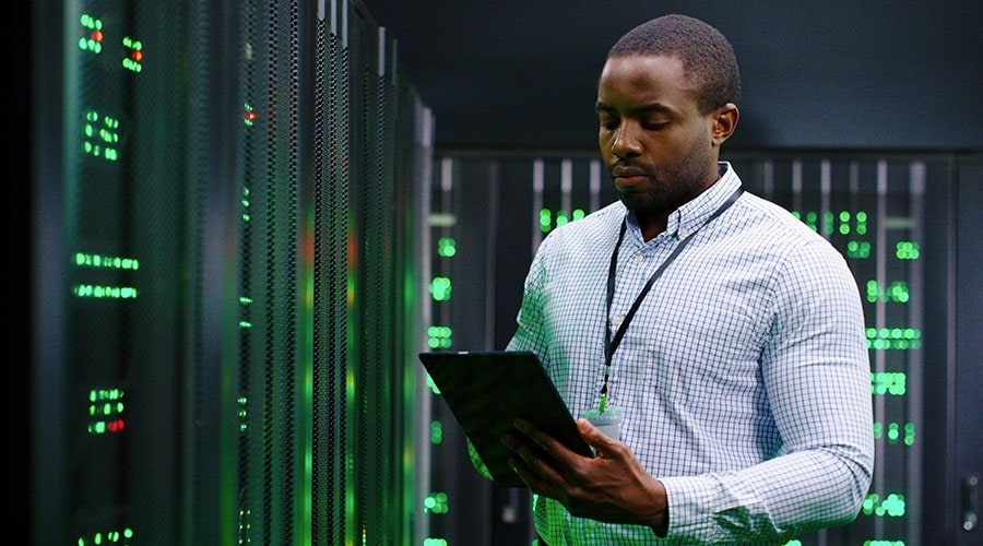 Technician looking at tablet in data center