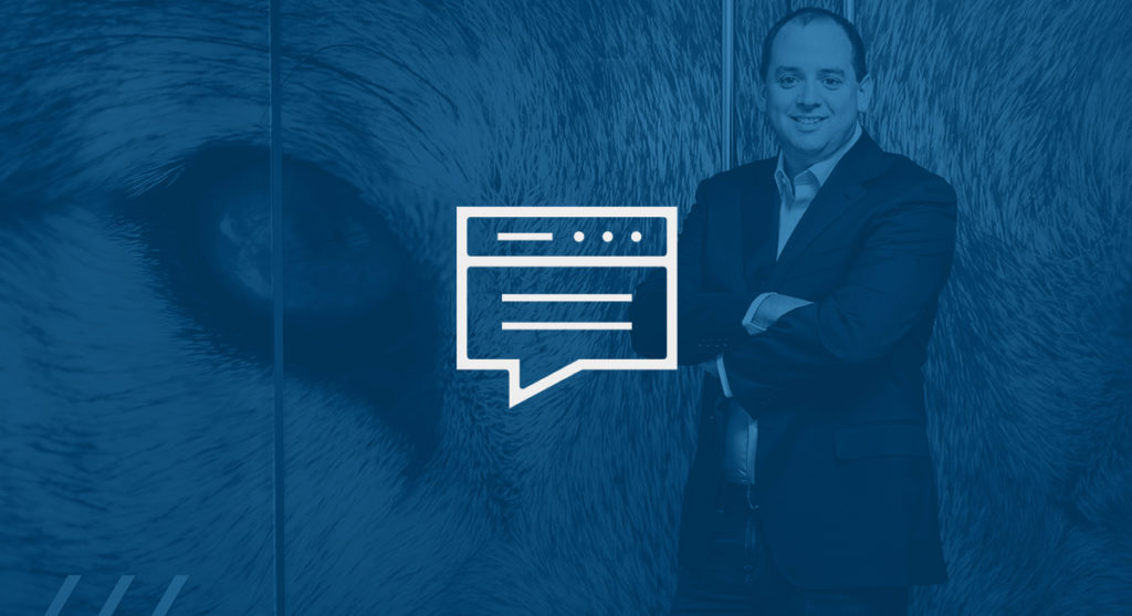 Nick Schneider in front of a graphic of a wolf