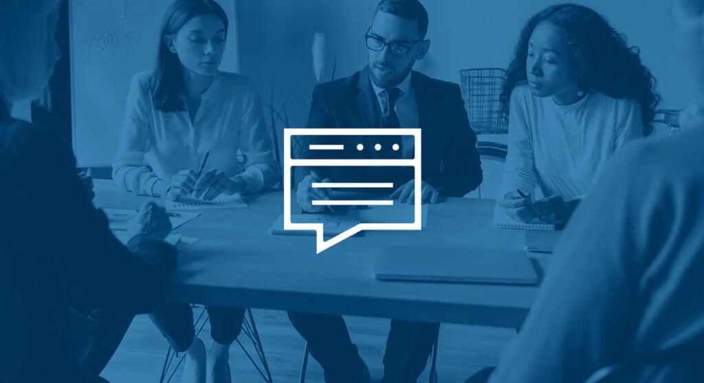 Group of co-workers in business attire sitting around a table.