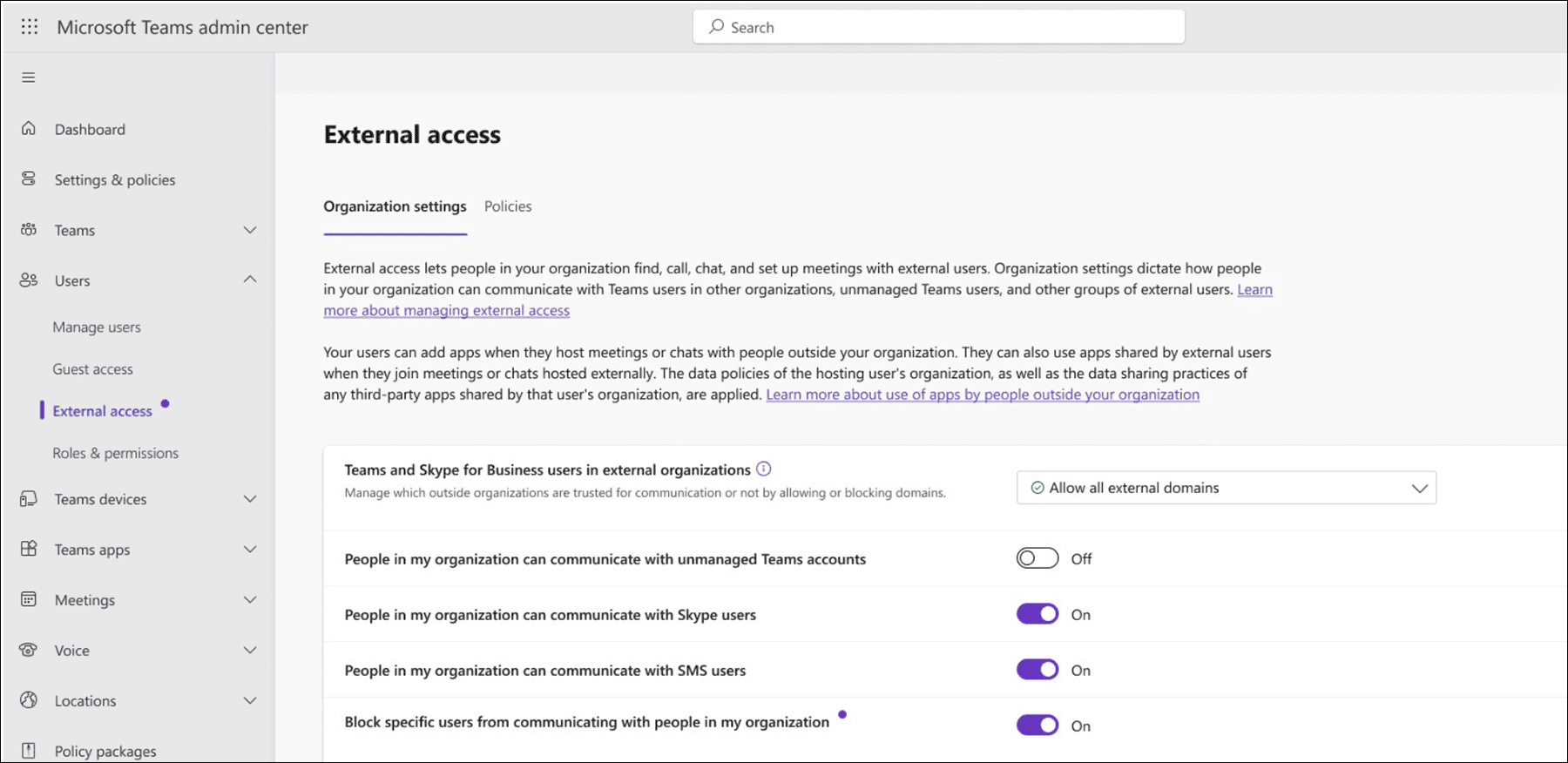 Microsoft Teams admin center External access settings page showing Organization settings tab with “Allow all external domains” selected and toggles for unmanaged Teams accounts, Skype users, SMS users, and blocking specific users